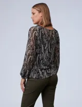Blusa de gasa estampada en blanco y negro, marca Tahari. Tiene cuello redondo con escote en V y lazo, mangas largas con puño elastizado y forro a tono.