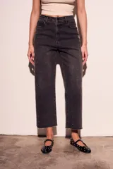 Pantalón de jean negro con efecto gastado y pequeños brillos. Corte recto, tiro alto y terminación desflecada.