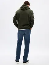 Jean de corte slim, color azul medio con efecto lavado, confeccionado en denim con cinco bolsillos y cierre frontal con botón y cremallera.