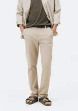 Pantalón de vestir color verde oscuro, de corte slim, con bolsillos laterales y traseros. Se ajusta a la cintura con botón y cierre.