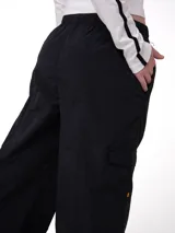 Pantalon cargo de nylon color negro, con cintura elástica y cordón ajustable. Presenta un corte de pierna relajada, bolsillos laterales y un bolsillo cargo con etiqueta de la marca Cat.