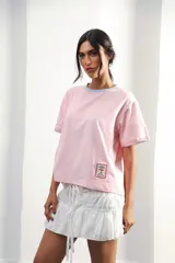 Remera de algodón color azul marino, corte relajado con hombro caído. Presenta cuello redondo blanco y bordado a mano en contraste en los puños de las mangas. Tiene un parche bordado en la parte inferior del frente.