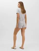 Pijama de dos piezas confeccionado en tejido soft con estampado animal print gris y blanco. Incluye una remera de manga corta con escote en V, detalle plisado en el frente y aplique de puntilla, y un short con cintura elastizada.