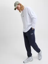 Pantalón de jogging color azul marino, con corte regular y tejido de punto con interior afelpado. Presenta cintura elástica con cordón ajustable y puños acanalados en los tobillos. Incluye un pequeño logo estampado en blanco en la parte superior de la pierna.