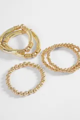 Set de cinco pulseras elásticas de diseño minimalista en color plateado, compuesto por piezas de diferentes grosores y texturas de cuentas metálicas.