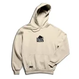 Canguro de abrigo color beige con capucha ajustable, bolsillo estilo canguro en el frente, puños y cintura elasticados. Presenta un parche bordado en el pecho con una figura encapuchada leyendo un periódico y una taza humeante al lado.