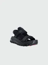 Sandalias negras con tiras ajustables de velcro, suela gruesa con tacos y detalles en rojo.