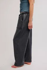 Pantalón harem amplio color gris oscuro con efecto lavado, tiro caído, cintura elástica con cordón de ajuste y grandes bolsillos parche en la parte delantera.