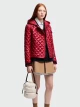 Bolso tipo saco (bucket bag) acolchado color crema, con cordón ajustable en la parte superior y asas cortas negras.