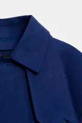 Cazadora de cuello solapa y manga larga, color azul, con diseño cruzado y cierre frontal con botones.