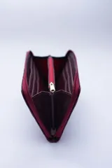 Billetera rectangular con cierre perimetral, confeccionada en cuero con textura de reptil. Cuenta con múltiples compartimentos internos para tarjetas, documentos y billetes, además de un bolsillo interior con cierre para monedas.