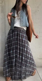 Pollera larga plisada con estampado a cuadros en tonos marrón y celeste, con pretina elástica.
