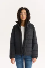 Campera puffer negra de Levi's con cuello alto, cierre frontal con botones a presión y bolsillos laterales.