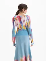 Top de punto ajustado de manga larga y escote redondo, con estampado floral difuminado en tonos azules, rojos y amarillos.