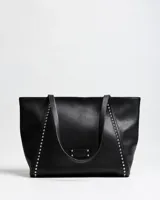 Cartera tipo tote bag de cuero sintético negro, con doble asa de hombro y detalles de tachas metálicas plateadas en los laterales frontales.