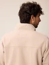 Campera de polar color verde militar, con cierre frontal completo, cuello alto y bolsillo en el pecho con cierre y detalle en tela técnica.