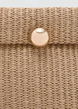 Cartera de mano de tejido trenzado color beige, con solapa y cierre de botón a presión metálico dorado. Incluye una correa de muñeca en tono marrón y herrajes dorados.