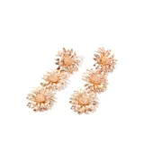 Aros colgantes dorados con tres flores metálicas cada uno.