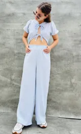 Pantalón palazzo celeste con rayas verticales blancas y cintura elastizada.