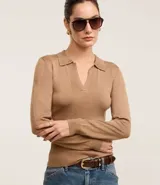 Blusa de punto ajustada color negro, con cuello polo y escote pronunciado en V. Presenta un tejido acanalado vertical en el torso y mangas largas.