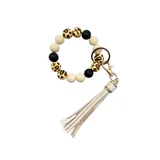Llavero pulsera con cuentas de silicona en color blanco, negro y animal print, con flecos de ecocuero color beige.