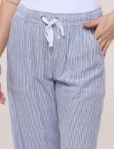 Pantalón de lino de calce holgado y caída ligera, con estampado de rayas verticales en tonos celestes y blancos. Cuenta con cintura elastizada fruncida con cordón ajustable al frente, bolsillos laterales y pierna recta.