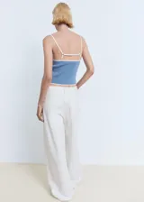 Top de punto fino celeste con tirantes finos y ribetes blancos en contraste, de diseño entallado.