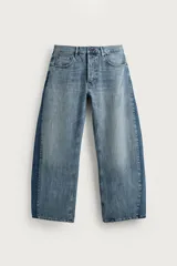 Jeans loose balloon fit de denim de algodón con diseño de cinco bolsillos y efecto lavado. Presentan bandas laterales en contraste y cierre frontal con cremallera y botón.