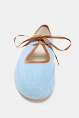 Bailarina celeste de tela denim con puntera redondeada, ribete marrón y lazo de ajuste marrón.