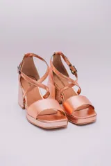 Sandalias de cuero color cobre con plataforma y taco cuadrado. Tiras cruzadas sobre el empeine y pulsera con hebilla al tobillo.