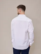 Camisa negra de algodón de manga larga, con cuello clásico y cierre frontal con botones.