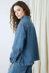 Campera de denim azul con múltiples bolsillos frontales con solapa, cierre frontal de botones metálicos y cuello camisero.