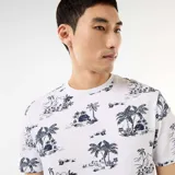 Remera blanca con estampado tropical de palmeras y paisajes en azul oscuro, de manga corta y cuello redondo.