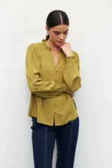 Camisa blanca de manga larga con puños elastizados, cuello mao y escote en v, botones forrados en la misma tela.