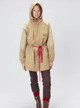 Campera tipo piloto con capucha, cierre frontal con botones y detalle de costuras en zigzag. Presenta cordones ajustables en la cintura y capucha, puños elásticos y logo bordado en el pecho.