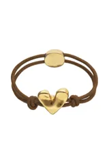 Pulsera ajustable de hilo elástico doble color marrón, con un dije central de corazón tridimensional bañado en oro 18k. Presenta un cierre de metal dorado y un nudo decorativo en el extremo opuesto al corazón.