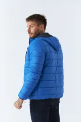 Campera puffer azul eléctrico, reversible, con cuello alto, cierre frontal con cremallera, bolsillos laterales con cierre y logo de goma en el pecho.