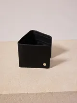 Billetera triplicable de cuero sintético color marrón con múltiples compartimentos internos.