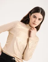 Polera dorada de cuello alto y manga larga, confeccionada en tejido elastizado con terminación metalizada.