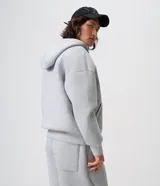 Campera boxy de malla scuba color gris melange, con capucha, cierre frontal completo y bolsillos laterales ocultos.