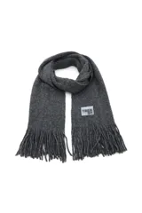 Bufanda larga de tejido de punto grueso color gris oscuro con flecos en los extremos y etiqueta con logo de la marca.