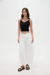 Musculosa crop de morley negro con tirantes finos, escote en V decorado con detalles de encaje y un pequeño lazo en el centro.