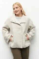 Tapado corto color beige de tejido grueso con cuello alto, cierre frontal con botones grandes veteados y bolsillos delanteros.