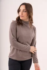 Polera de lanilla color champagne, de cuello alto y manga larga.