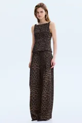 Chaleco de sastrería entallado, con escote cuadrado, breteles anchos y cierre frontal de botones. Presenta un diseño con estampado animal print de leopardo en tonos marrones y negros.