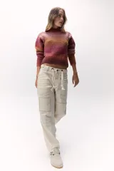 Sweater tejido de punto en hilado bouclé con degradé de colores naranja y rosa. De calce al cuerpo, cuello alto y suave textura.