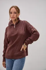 Sweater de punto color marrón chocolate, con cuello alto y cierre frontal parcial. Presenta un diseño con texturas combinadas, incluyendo paneles de punto trenzado en las mangas y el frente, y un tejido de punto texturizado en el centro.