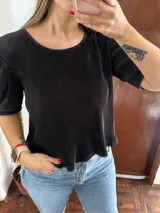 Blusa negra plisada de manga corta y cuello redondo.