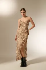 Vestido midi de poliéster con estampado animal print, diseño asimétrico con volados en el ruedo, escote en V y breteles finos.