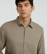 Camisa masculina de manga larga color beige, con cuello inglés y abotonado frontal. Corte comfort.